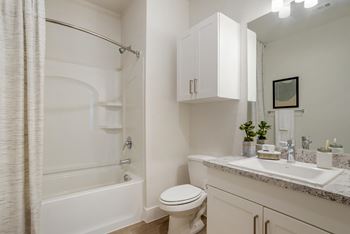 A white bathroom with a toilet, sink, and bathtub.